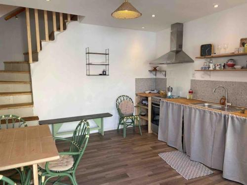 une cuisine avec une table, des chaises et un évier dans l'établissement La Torre, à Maraussan