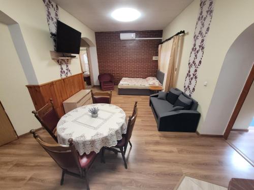 ein Wohnzimmer mit einem Tisch und einem Sofa in der Unterkunft Penzión Korzo in Štúrovo