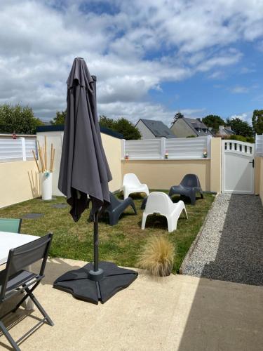 d'une terrasse avec un parasol, des chaises et des tables. dans l'établissement DUDUCHE Family, à Damgan