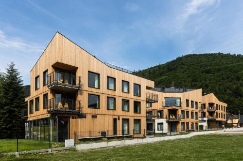 un grand bâtiment en bois avec une colline en arrière-plan dans l'établissement XYZ eXtreme You Zen, à Szczyrk