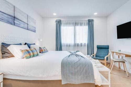 1 dormitorio con cama blanca, escritorio y silla en Home2Book Casa Boissier, Breakfast Included, en Las Palmas de Gran Canaria