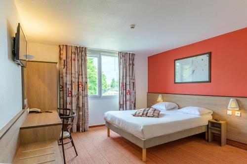 Habitación de hotel con cama y escritorio en Ace Hôtel Paris Roissy en Mitry-Mory