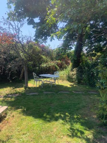 a picnic table and a chair in a yard at Lancresse in Wool