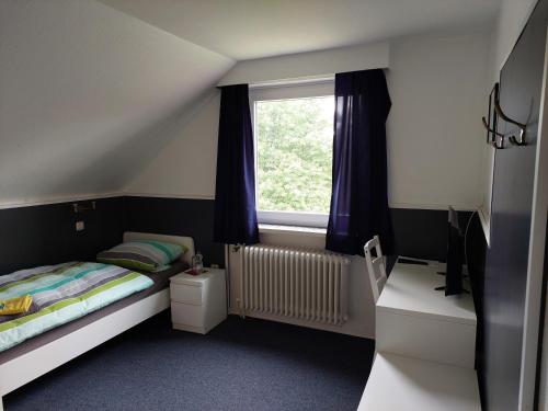 a small bedroom with a bed and a window at Landhaus Luttum in Kirchlinteln