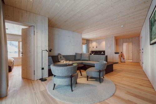 uma sala de estar com um sofá, uma mesa e cadeiras em Familien Natur Resort Moar Gut em Grossarl