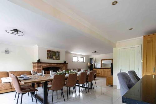 a dining room with a table and chairs and a fireplace at Huge 6 Bed House with Entertainment room and Hotub in Southampton