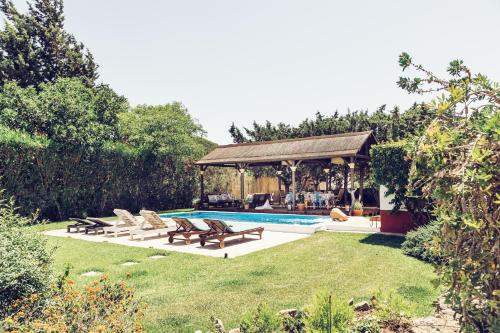 un patio trasero con piscina y cenador en Casa Dehesa de las yeguas, en Cádiz