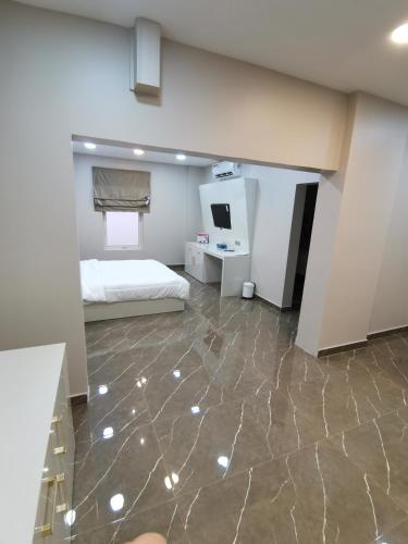 a bedroom with a bed and a desk in it at Marina in Sohar