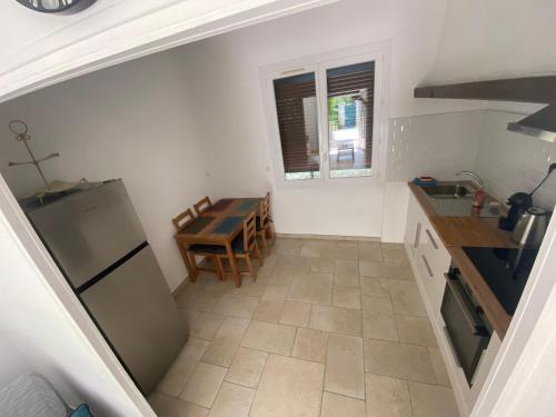 a small kitchen with a table and a refrigerator at Magnifique et paisible T2 in Marseille