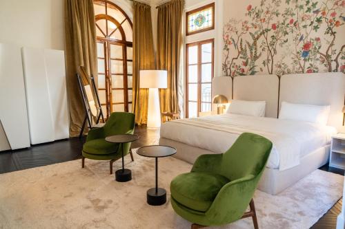ein Schlafzimmer mit einem Bett und zwei grünen Stühlen in der Unterkunft Palacio Ca Sa Galesa in Palma de Mallorca
