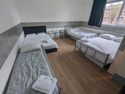 a group of three beds in a room at Hotel-Chao NL 24 hours open in Utrecht