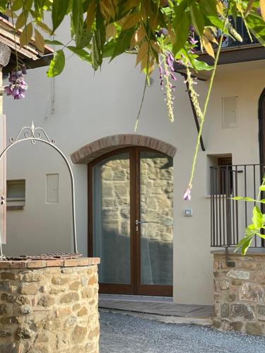 una porta d'ingresso di una casa con un muro di pietra di CASA DI ELENA a Montalcino