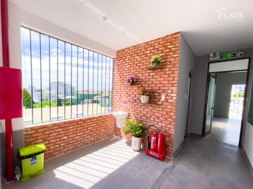 a room with a brick wall and a large window at Khách sạn Lavie Hotel Quảng Ngãi in Quang Ngai