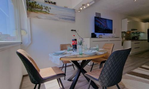 a dining room with a table and chairs and a kitchen at Soft apartment in Solin next to Split in Solin