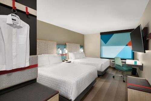 um quarto de hotel com duas camas e uma secretária em avid hotels - Austin - Tech Ridge, an IHG Hotel em Austin