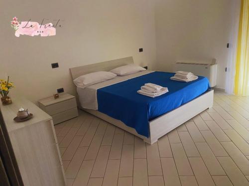 1 dormitorio con 1 cama con sábanas azules y toallas en LA FIESTA en Angri
