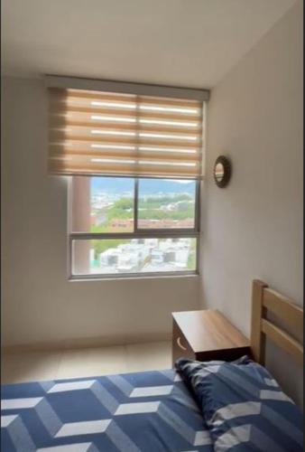 sypialnia z oknem z łóżkiem i stołem w obiekcie Mirador de La Pradera w mieście Dosquebradas