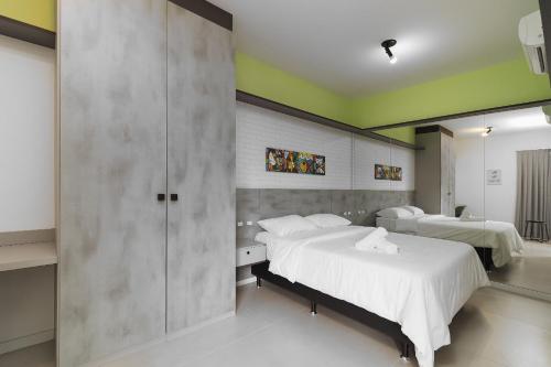 1 dormitorio con 2 camas y pared en Apto em cond Thai Beach Home Spa TBS1105, en Florianópolis