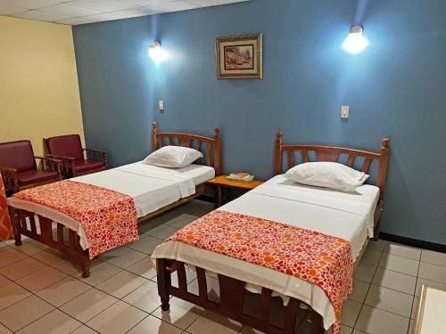 um quarto com duas camas e duas cadeiras em Sundeck Suites em Boissiere Village