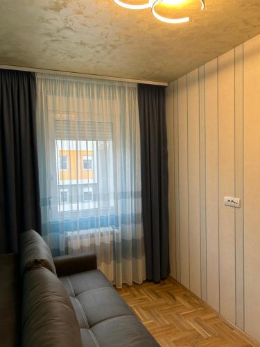 a living room with a couch and a window at Apartman Branković Pirot-Zapadni Kej 58 in Pirot