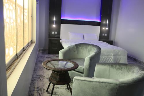a bedroom with a bed and a chair and a table at مارينا للغرف الفندقية in Sohar