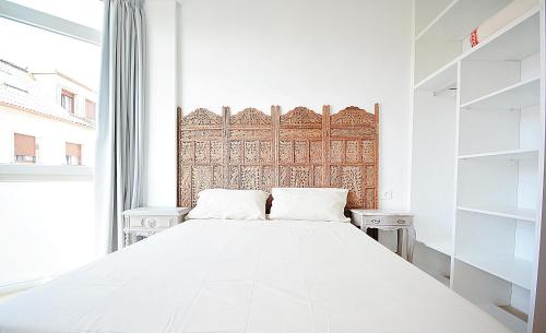 a white bedroom with a large bed and a window at Céntrico apartamento en Vilanova de Arousa in Villanueva de Arosa