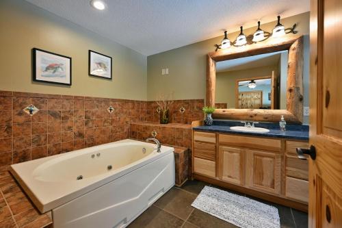 ein Badezimmer mit einer Badewanne, einem Waschbecken und einem Spiegel in der Unterkunft Lost Dutchman in Hayward