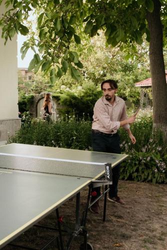 a man standing next to a ping pong table at Villa Oselya in Kyiv