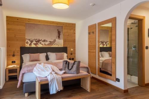a bedroom with a bed and a large painting on the wall at Hotel Meida in Pozza di Fassa