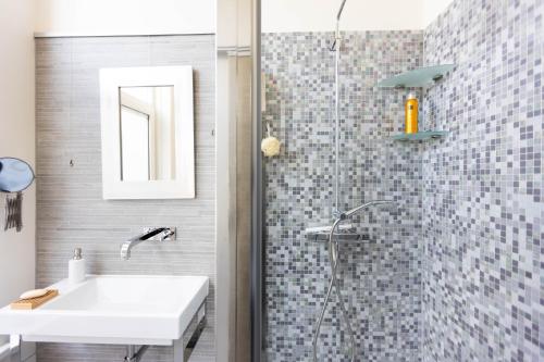 W łazience znajduje się biała umywalka i prysznic. w obiekcie B&B Brouwersvaart w mieście Haarlem