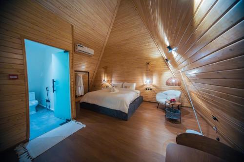 1 dormitorio con 1 cama en una habitación con paredes de madera en Terhabb Cottages, en Abha