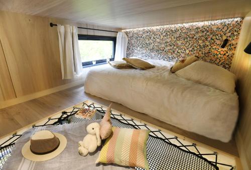 a bedroom with a bed and a teddy bear on a rug at La tiny house de la Blandinière in Vertou