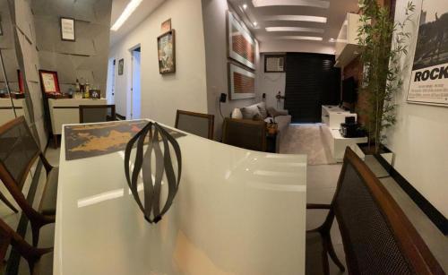 um quarto com uma mesa e uma sala de estar em Lindo Apto com Escritório, Varanda e Garagem no Centro de Niterói em Niterói