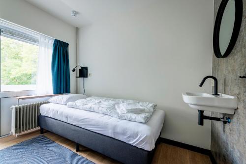 锡塔德The Tower Sportshostel的一间卧室配有床、水槽和窗户