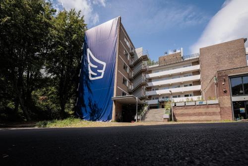 un edificio con una señal azul en el costado. en The Tower Sportshostel en Sittard