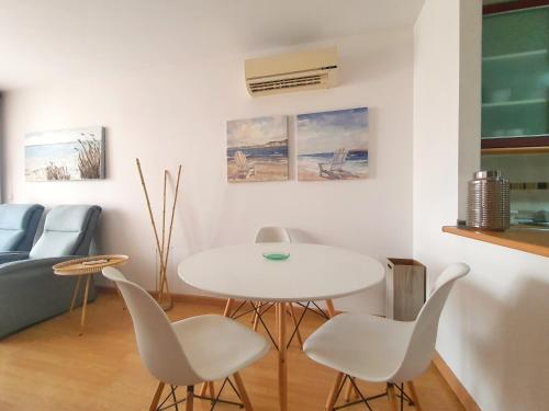 sala de estar con mesa blanca y sillas en Apartamento con Aire Acondicionado, Piscina, Wifi y Smart TV - by Aloha Palma en Águilas