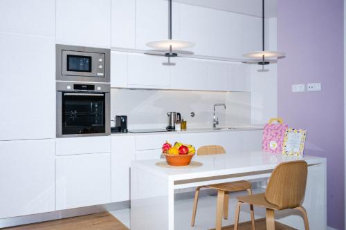 una cucina bianca con tavolo e sedie di Design-Apartment Olhão by Sisters of Paradise a Olhão