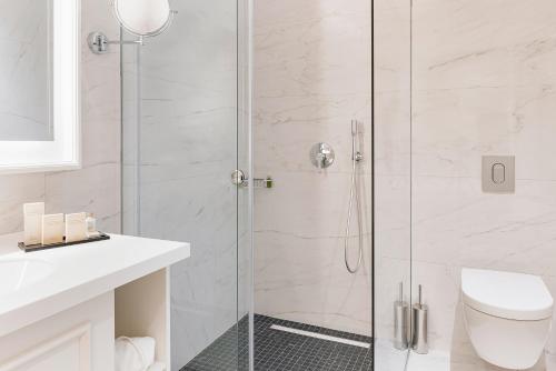 a bathroom with a shower with a toilet and a sink at Heritage Grand Perast By Rixos in Perast