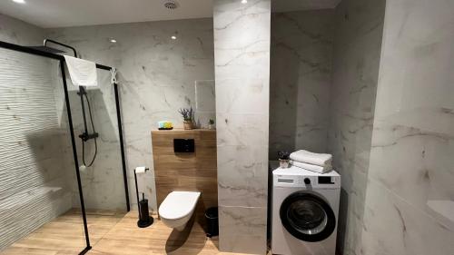 une salle de bain avec douche et machine à laver dans l'établissement Rising Sun 3 by Housine,pl, à Zator