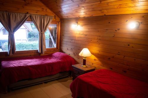 sypialnia z 2 łóżkami w drewnianym domku w obiekcie Pura Patagonia w mieście Villa La Angostura