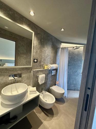 a bathroom with two sinks and a toilet and a mirror at The Upper House in Riomaggiore