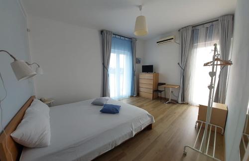 a bedroom with a white bed and a desk and window at CASA MONTEFINESE in Casamassima