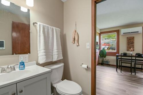 bagno con servizi igienici, lavandino e specchio di Tranquil Lakefront Cottageviewsfishing 