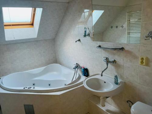 a bathroom with a bath tub and a sink at Pokoje s vlastní koupelnou a WC in Doksy