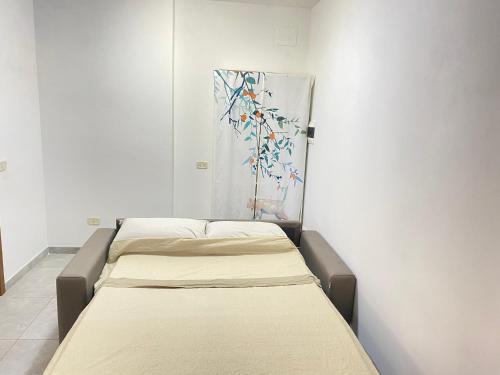 una fila de camas en una habitación con una pintura en la pared en Orlandi Sun casa superficie 50 mq, en Sarnano