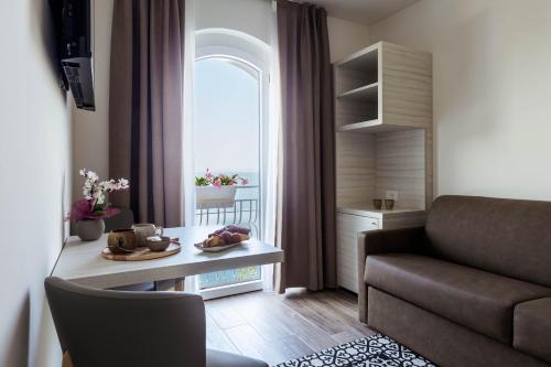 a living room with a couch and a table and a window at Hotel Giardinetto in Garda
