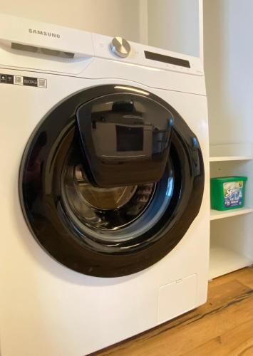 a white washing machine with a device inside of it at BaMo Studio - city living downtown in Klagenfurt