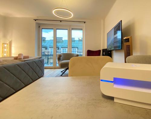 ein Wohnzimmer mit einem Sofa und einem TV in der Unterkunft BaMo Studio - city living downtown in Klagenfurt am Wörthersee