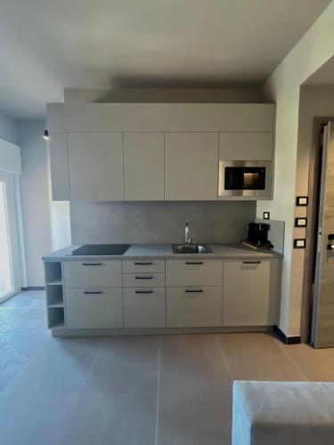 a kitchen with white cabinets and a sink at The Upper House in Riomaggiore