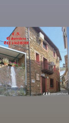 a brick building with a sign on the side of it at Casa Rural El Chorritero in Ovejuela